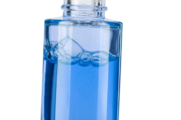 Teil einer Flasche mit blauer kosmetischer Flüssigkeitsnahaufnahme auf einem weißen Hintergrund