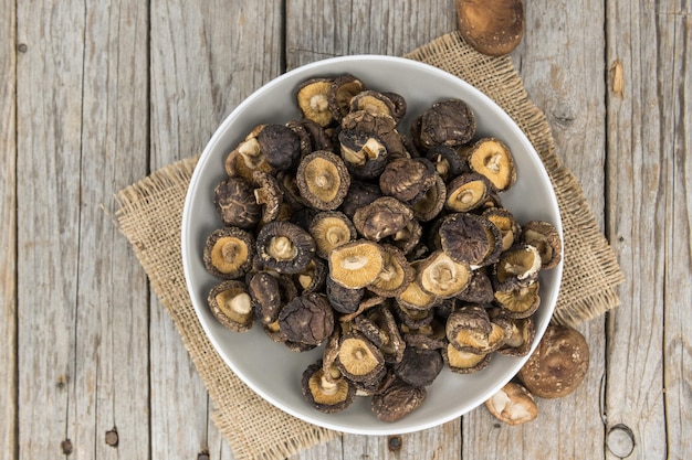 Teil Shiitake-Pilze getrocknet auf selektivem Fokus des hölzernen Hintergrundes Beschneidungspfad eingeschlossen