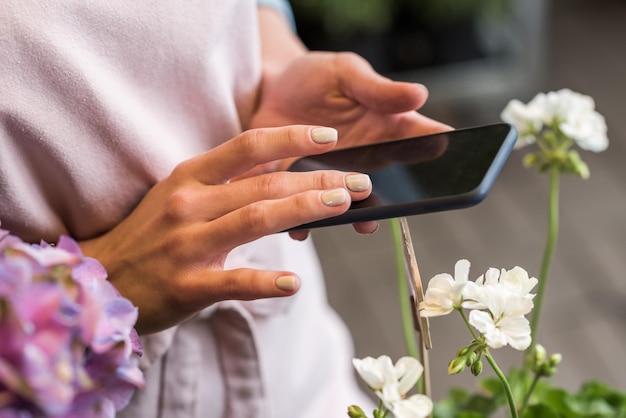 Teilansicht einer Frau, die ein Smartphone mit leerem Bildschirm verwendet