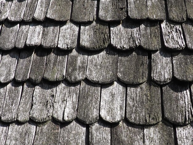 Las tejas del techo como una cubierta de techo rural tradicional Azulejos de losa cruzada en ángulo agudo material de la pieza del techo primer plano Arquitectura de madera de antiguos artesanos carpinteros Fondo natural