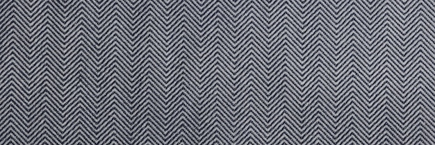 Tejido gris con patrón en zigzag como fondo Primer plano de textil gris y blanco