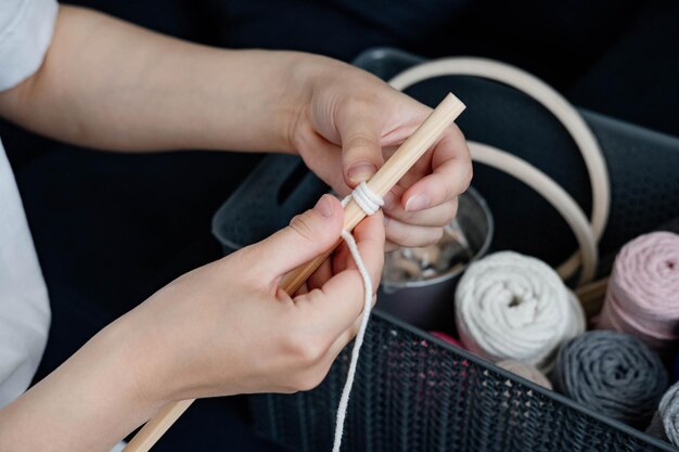 Foto tejiendo macramé en casa mano de una mujer cuando está haciendo macramé