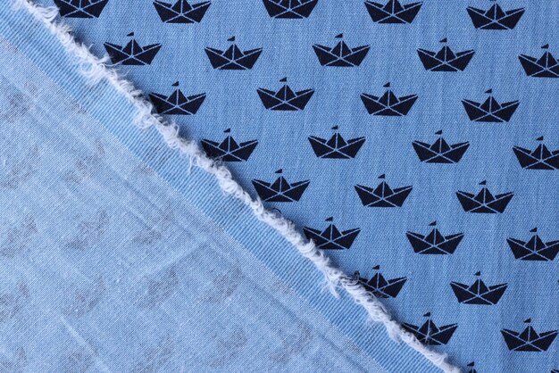 Tela de algodón azul con estampado de barcos para ropa de niños vista superior material textil doblado