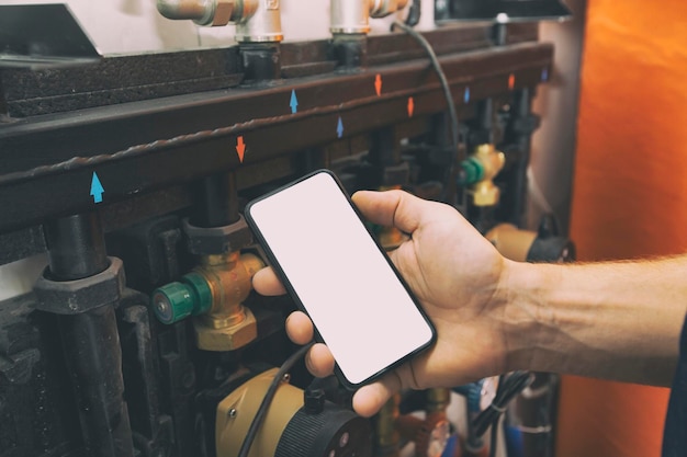 Tela branca em branco no telefone na mão de encanadores em luvas de proteção para reparo de casa ou construção ou instalação de sistema de aquecimento