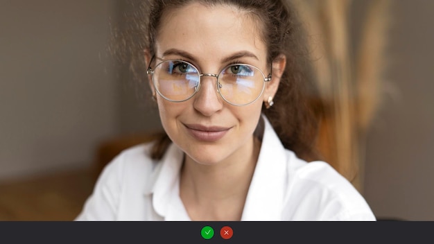 Foto tela de chamada de vídeo uma mulher com óculos de lata olá olha para a câmera sorri