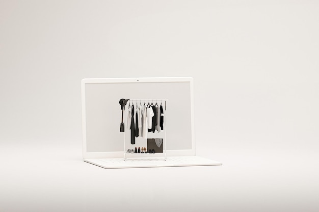 Tela de laptop 3d com roupas de relógio grande penduradas em um rack em cores preto e branco 3d render