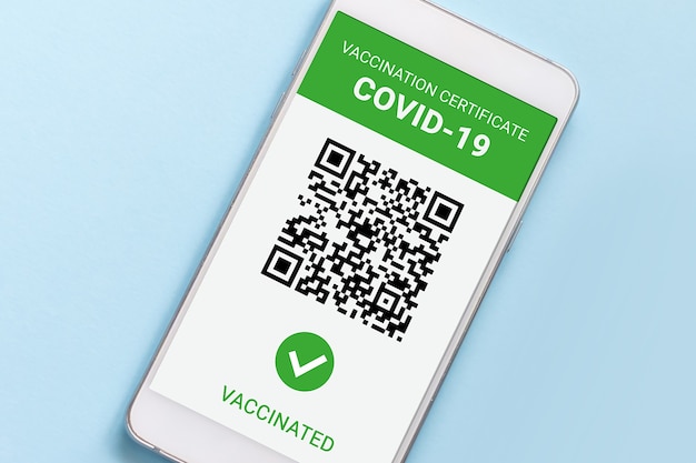 Tela de smartphone com aplicativo móvel COVID-19 vacinado isolado sobre fundo azul. Vista superior do certificado internacional de coronavírus