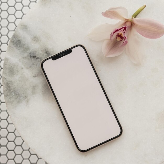 Tela de traçado de recorte em branco flor rosa do telefone móvel na mesa de pedra de mármore no fundo da telha de mosaico Modelo estético com espaço de maquete Vista superior plana