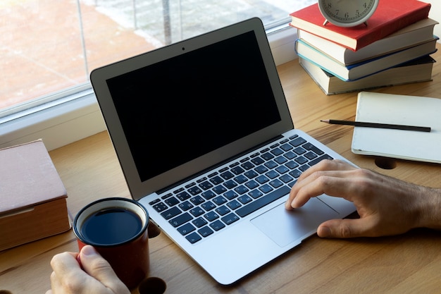 Tela do laptop em branco. Trabalhe ou estude online em casa em uma mesa e laptop.