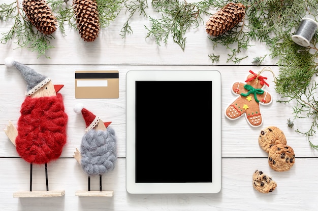 Tela do tablet na mesa de madeira branca com enfeites de Natal