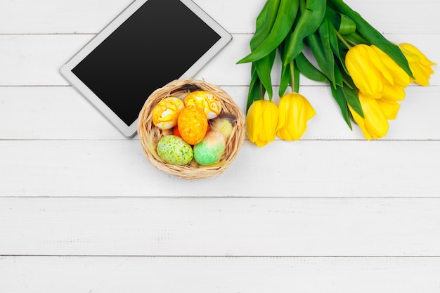 Tela do Tablet para mensagem e tulipas coloridas e ovos de Páscoa