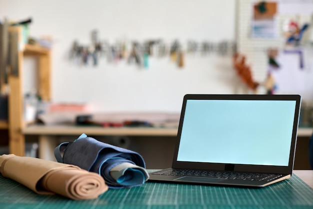 Tela em branco do computador sem fio em pé no local de trabalho do curtidor