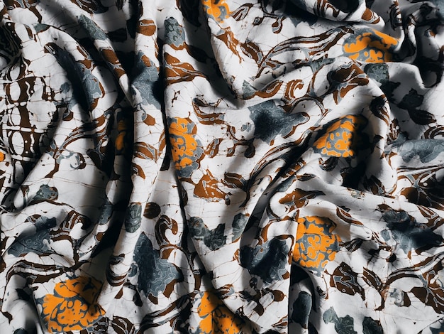La tela está estampada con un denso arreglo de motivos florales en tonos medios
