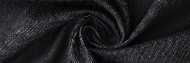 Tela de mezclilla gris arremolinada como fondo textil de jeans negros ondulados closeup