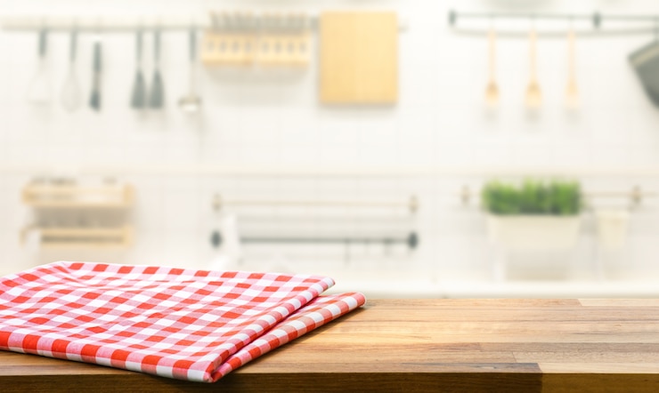 Foto tela roja, paño sobre la mesa de madera en el mostrador de la cocina de desenfoque