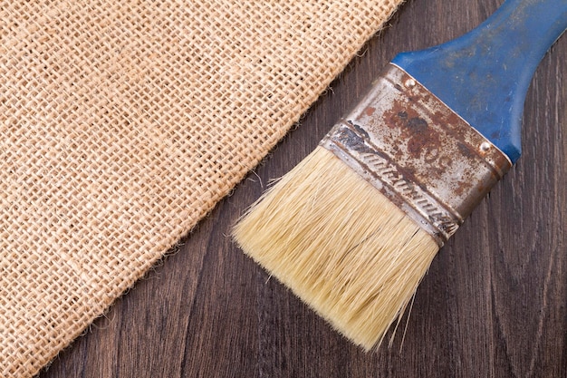 Tela de saco y cepillo viejo en la mesa de madera