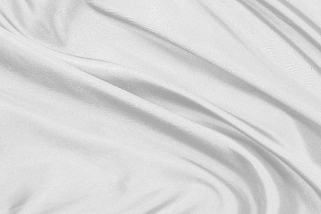 La tela de seda blanca elegante y suave o la textura de tela satinada de lujo se pueden utilizar como fondo de boda para un diseño abstracto de lujo con cortinas