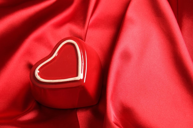 En una tela de seda roja hay un corazón rojo.
