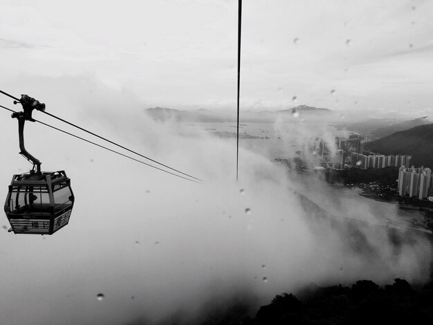 El teleférico aéreo se mueve hacia las nubes contra el cielo