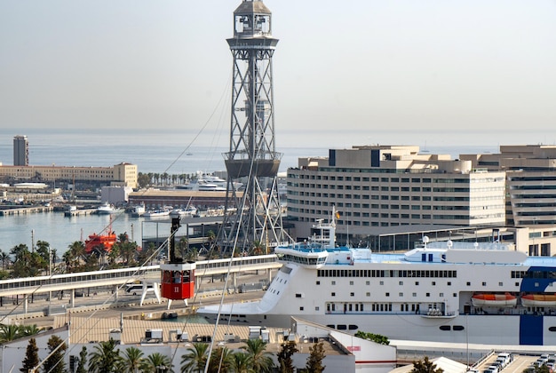 Teleférico de Barcelona en primer plano bajando al puerto y cruceros anclados