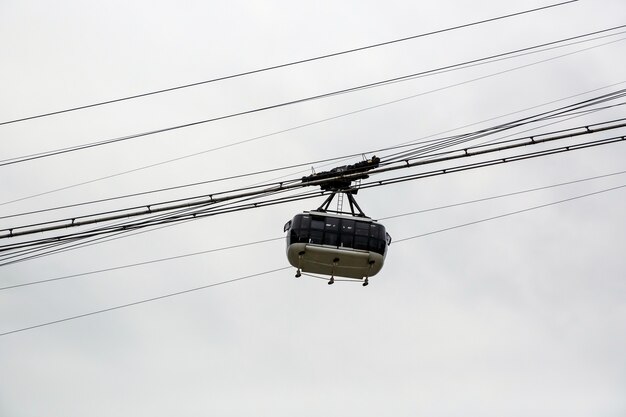 Foto teleférico de cabine com céu nublado.