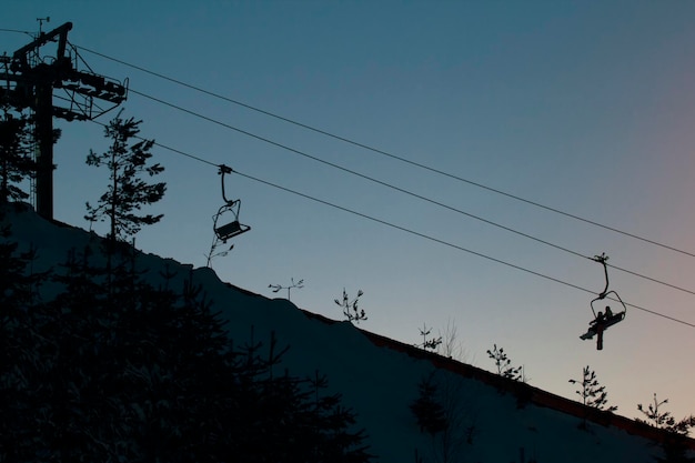 Teleférico no sky resort contra o céu noturno, silhueta, grande angular