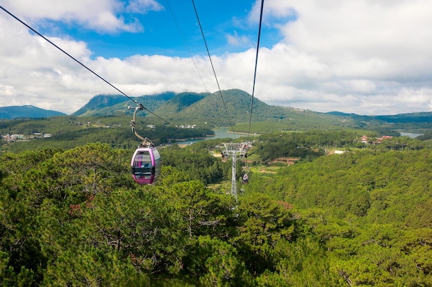 Foto teleférico con paisaje verde bosque y montaña y cielo azul