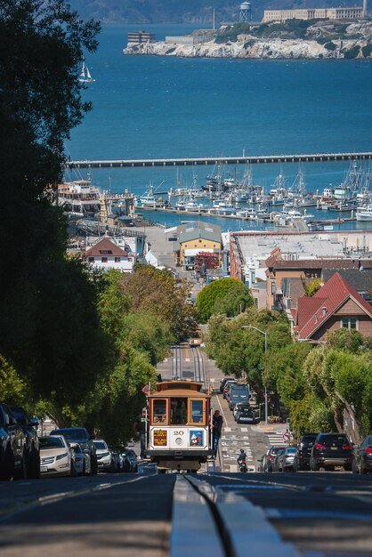 El teleférico de San Francisco subiendo el icónico puerto deportivo de la colina y Alcatraz en el fondo