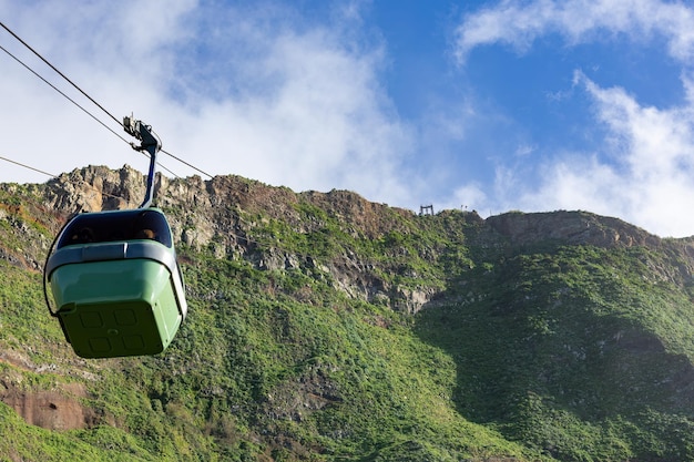 Teleférico sobre montañas con árboles y arbustos