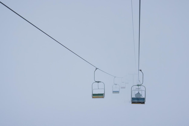 Teleféricos pendurados em cabos em uma névoa silenciosa