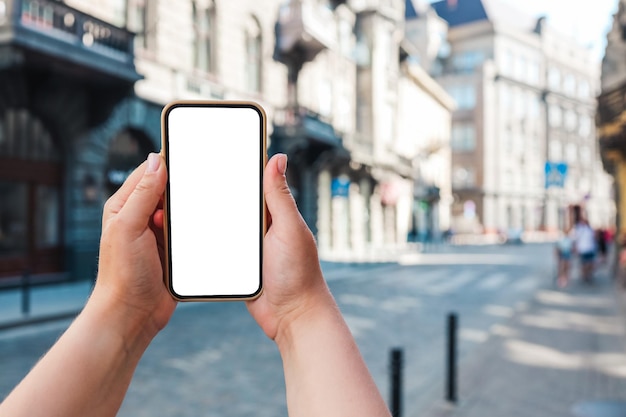 Telefon in der Hand mit einem Bildschirm auf dem Hintergrund der Stadt