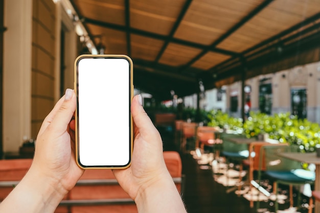 Telefon in der Hand mit einem Bildschirm auf dem Hintergrund der Stadt