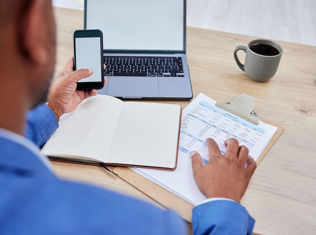 Telefon-Laptop und Mockup von Man Finance Planning Budget und Fintech für Bankdarlehen oder Hypothekenanträge Buchhaltungswebsite und Management schwarzer Mann mit Finanzsteuer- und Rechnungsdokumenten