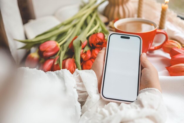 Telefon mit isoliertem Bildschirm auf dem Hintergrund von Frühlingsdekorationen