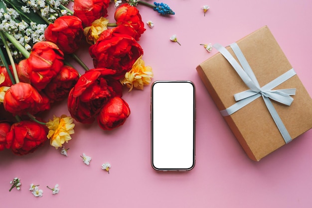 Telefon mit isolierter Bildschirm-Geschenkbox und Frühlingsblumenstrauß