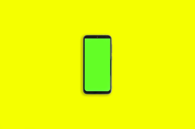 Telefon mit vertikalem grünem Bildschirm mit Chroma-Schlüssel, isoliert auf gelbem Hintergrund Mock Up Display Smartphone-Gadget für Werbung Ansicht von oben Mobiltelefon mit leerem, leerem Bildschirm Layout-Vorlage