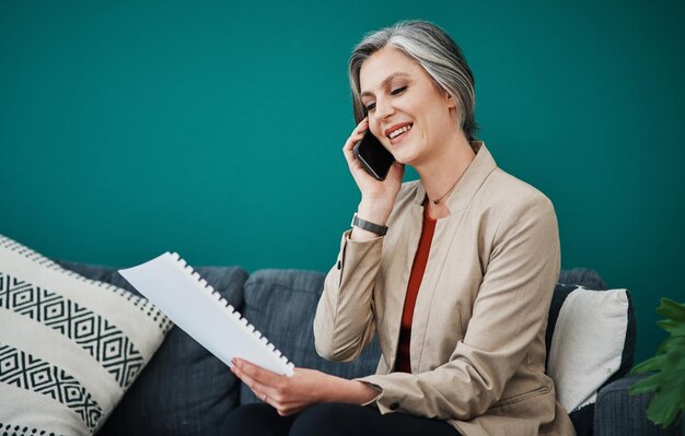 Telefonanruf glücklicher Frau und Lesen von Dokumenten im Heimbüro für Remote-Arbeit oder Hören auf dem Sofa Mobil-Check-Papierarbeit und reifer Freelancer oder Account-Manager mit Verkaufsbericht für den Kunden auf Mockup
