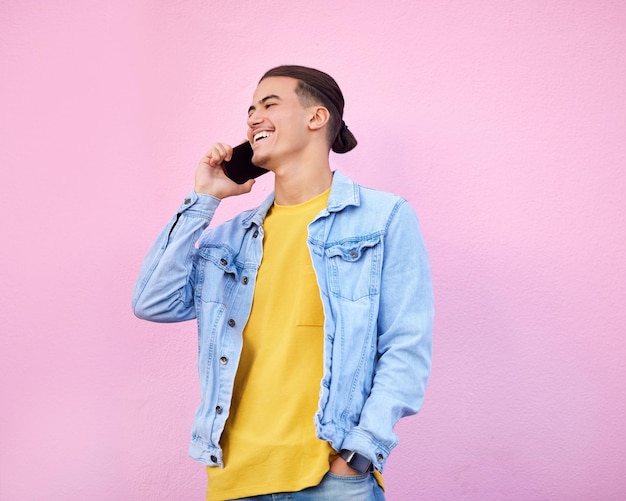 Telefonanruf Lächeln und Kommunikation gen z Mann spricht und glücklich isoliert auf rosa Hintergrund Smartphone urbane Mode und Vernetzung glückliches männliches Modell im Gespräch auf dem Handy mit Technologie