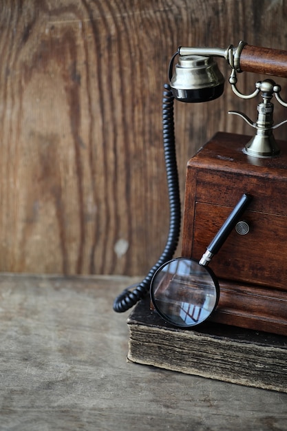 Telefone antigo e livro retrô em uma mesa de madeira