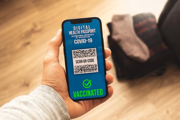 Telefone celular com aplicativo de passaporte de saúde, pessoa vacinada se preparando para viajar conceito