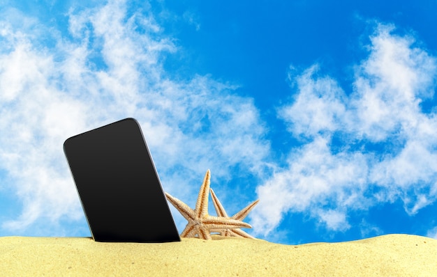 Telefone celular de toque na areia na praia