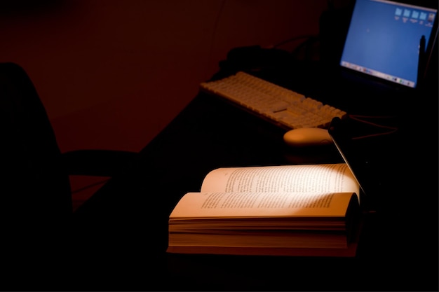 telefone celular e banco de energia na mesa ilumina leitura e livro de estudo com computador alimentado por bateria