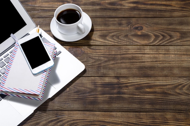 Telefone com laptop e xícara de café