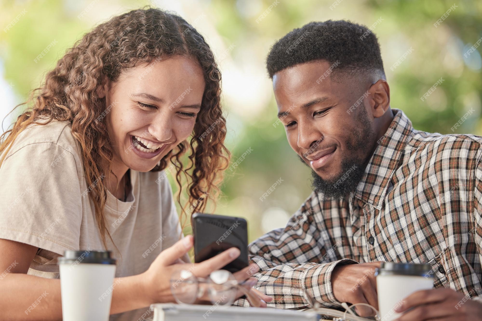 Telefone de casal inter-racial e rindo para piadas engraçadas de mídia  social ou meme com café no café homem e mulher felizes compartilham risadas  olhando para smartphone móvel com conexão 5g para entretenimento