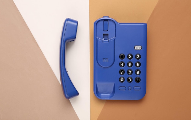 Telefone de escritório azul em um fundo colorido