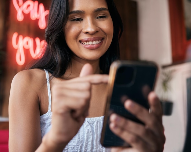 Telefone de mulher e café para enviar mensagens de texto ou navegar nas mídias sociais on-line para um meme ou conteúdo em um restaurante Rede social e móvel de cafeteria com uma cliente do sexo feminino lendo um blog na internet