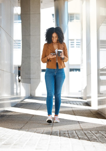 Telefone de mulher negra ou caminhando com café na cidade da cidade ou rua urbana na viagem matinal ou na hora do almoço no escritório Sorria feliz ou trabalhador criativo na tecnologia de comunicação móvel com chá