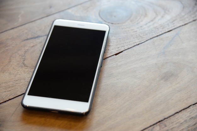 Telefone inteligente branco na caixa preta na mesa de madeira preparada para as equipes de gerenciamento entrar em contato com o cliente no negócio