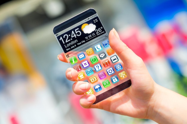 Foto telefone inteligente futurista com display transparente em mãos humanas. conceito de idéias inovadoras futuras reais e melhores tecnologias da humanidade.