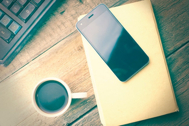 Telefone na agenda e café na mesa de madeira